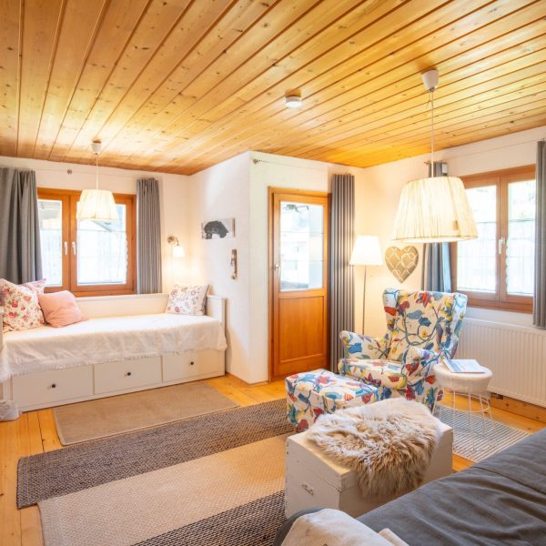 Gemütliches Wohnzimmer im Haus Berta, Montafon, mit Holzdecke, bequemen Sitzgelegenheiten und vielen.