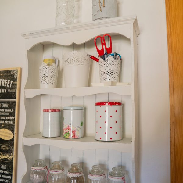 Weißes Küchenregal mit Glasbehältern, Küchenutensilien und Dekoration im Haus Berta, Montafon.